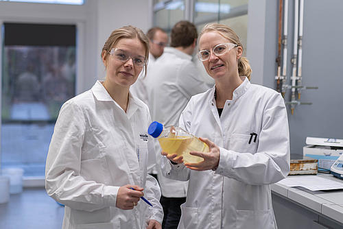 Foto mit zwei weiblichen Personen, mit Laborkitteln
