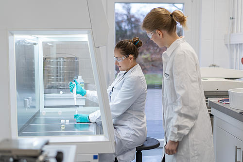 Zwei Frauen in weißen Kitteln führen Laborarbeiten durch